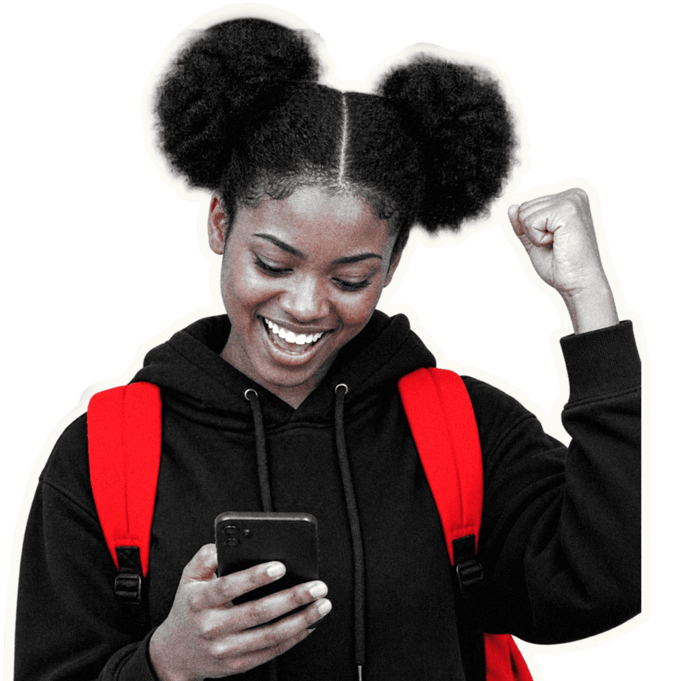 A student smiling at her phone with her fist in the air